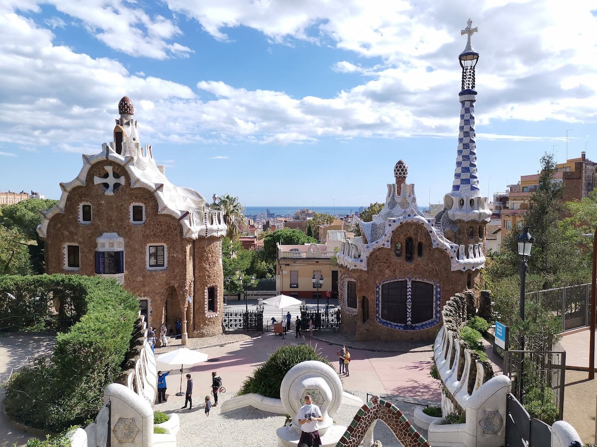 Mosaïques colorées et pavillons de Gaudí au Parque Guell, avec vue sur Barcelone