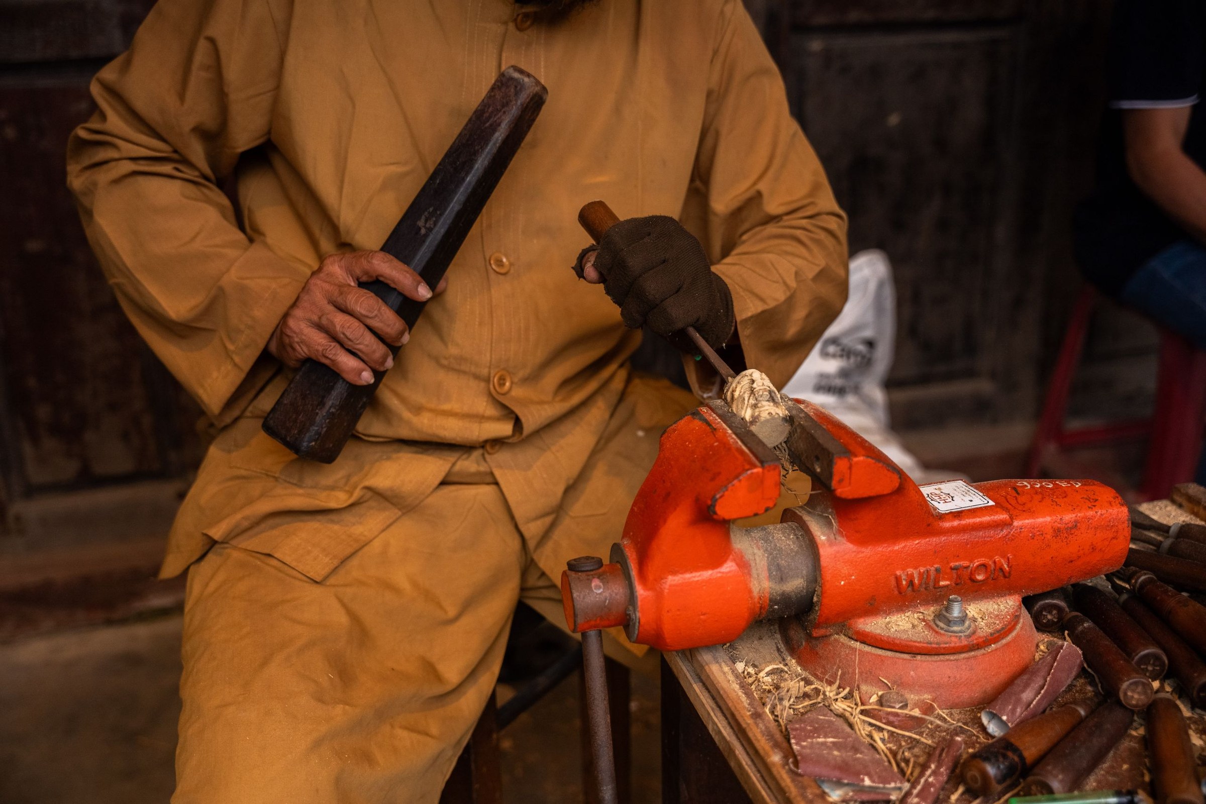 Apprenant réalisant un assemblage en bois sur un établi